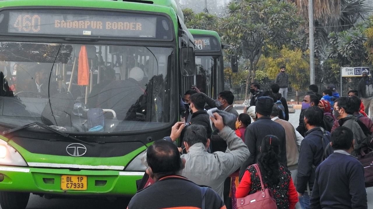 People try to board a DTC bus at Rail Bhawan bus stand in New Delhi. Credit: IANS Photo