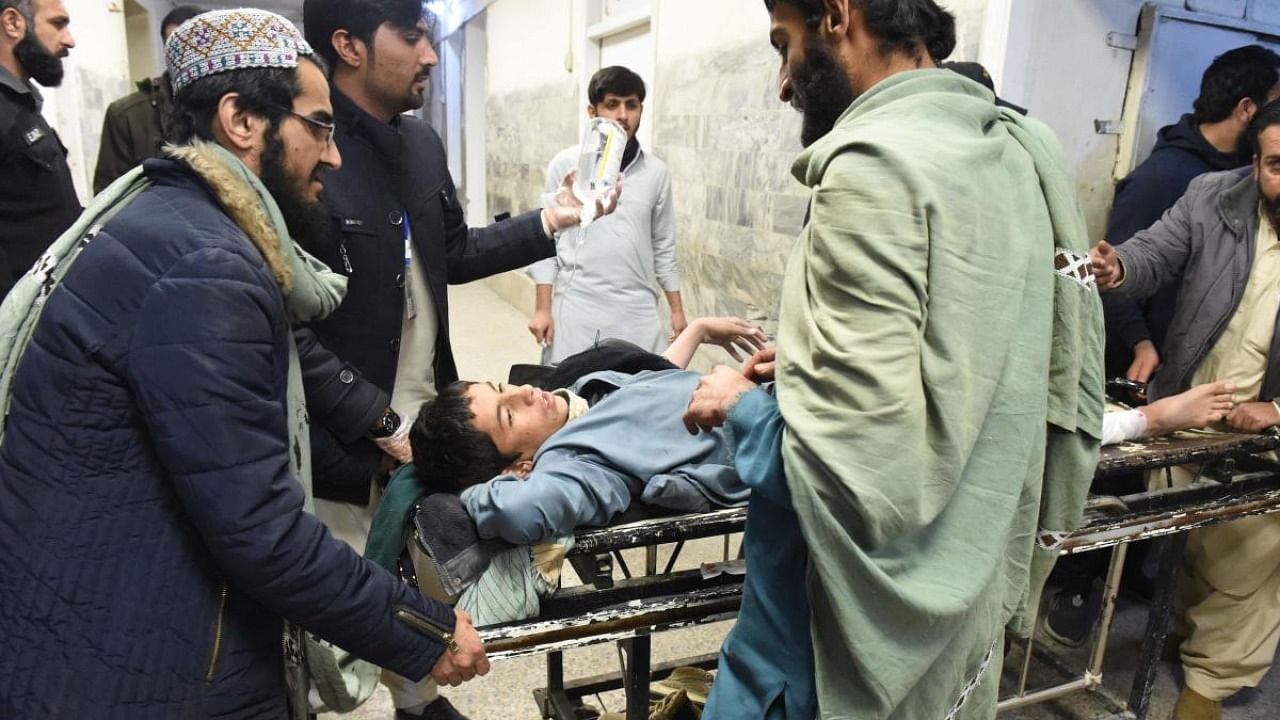 Political workers push an injured friend on a stretcher into a hospital after a bomb explosion in Quetta. Credit: AFP Photo