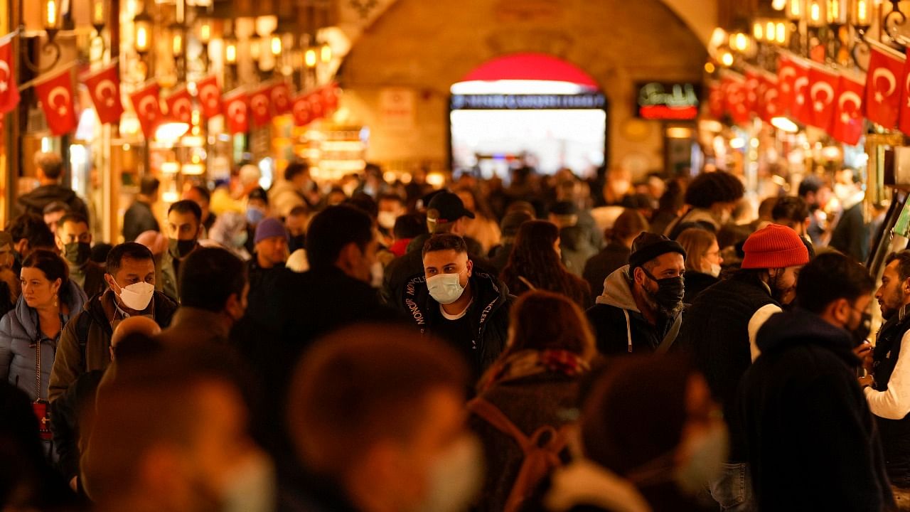 Pedestrians, some wearing protective face masks to prevent the spread of the Covid-19, walk at the Misir Carsisi, or Egyptian Bazaar, in Istanbul. Credit: AP/PTI File Photo