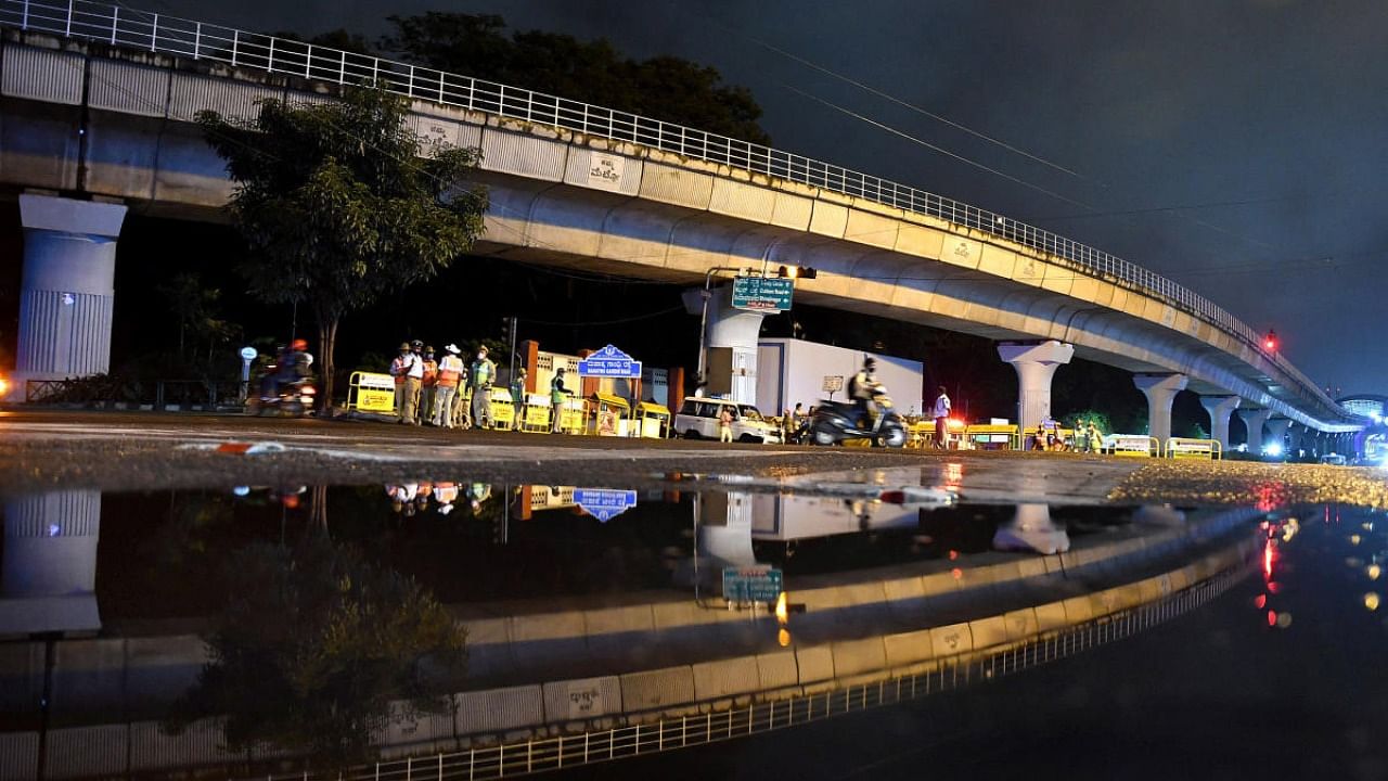 A view of MG Road, Anil Kumble circle and its reflection on a rainwater puddle show a deserted look as cops cordoned off the street to curb people from gathering on New Year's Eve in Bengaluru. Credit: DH Photo/Pushkar V