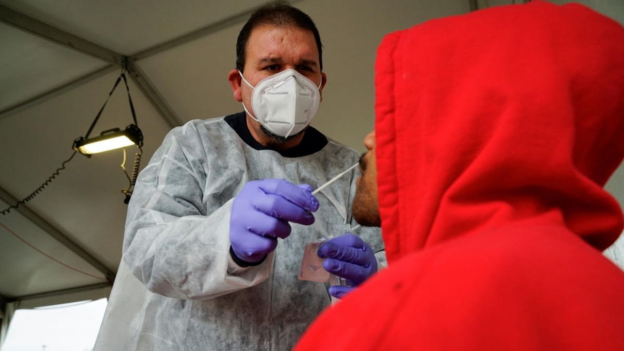 A healthcare worker takes swab sample for Covid-19 test. Credit: Reuters Photo