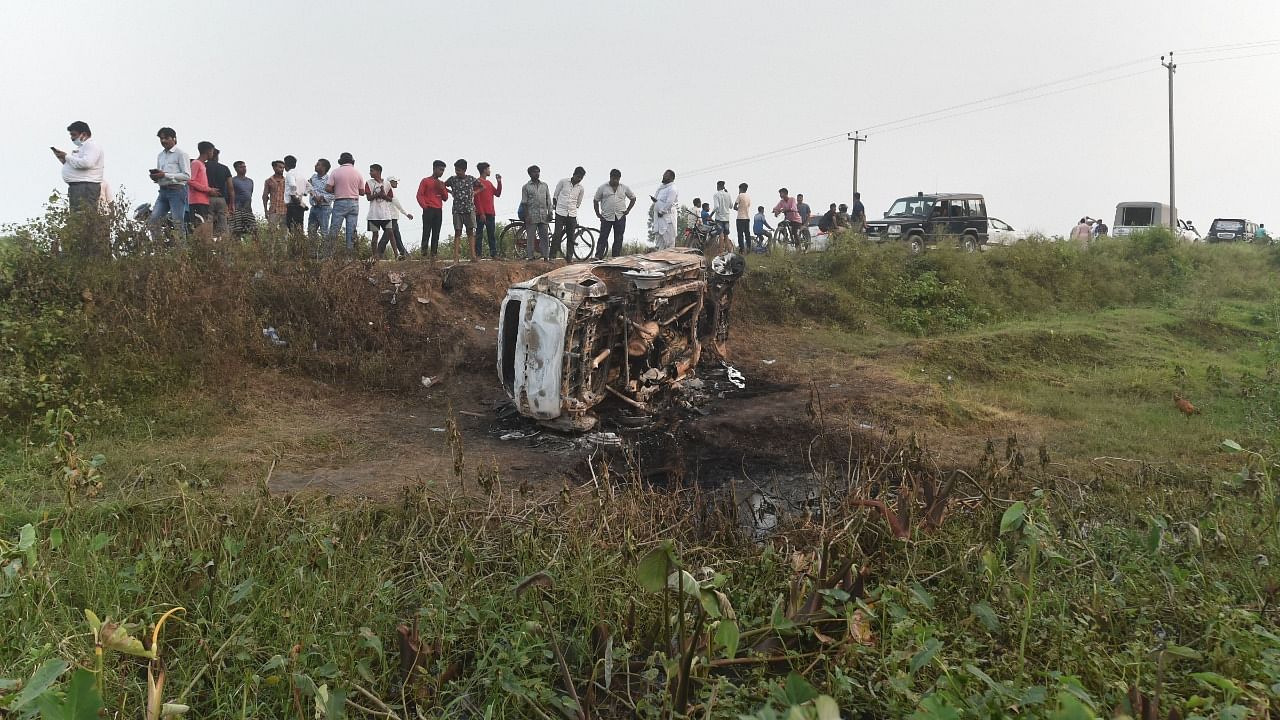 People take a look at the overturned SUV which was destroyed in Sunday' violence during farmers' protest, at Tikonia area of Lakhimpur Kheri district, Monday, October 4, 2021. Credit: PTI File Photo