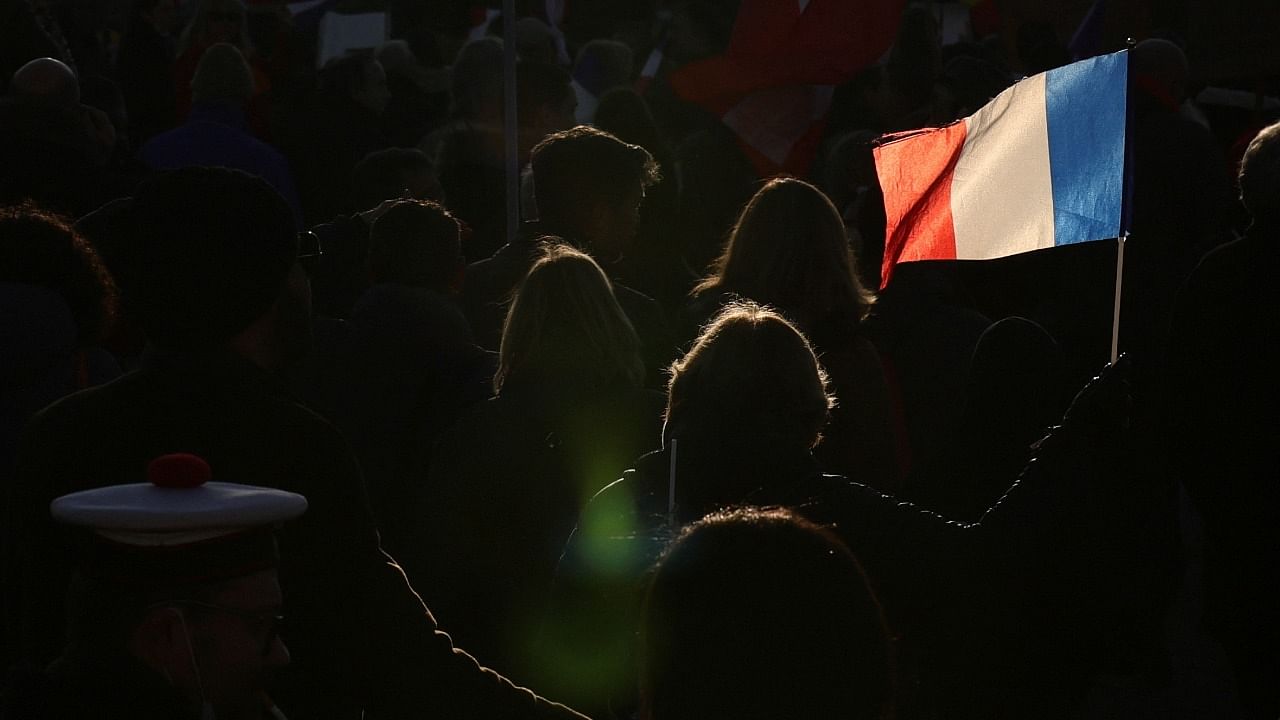 A woman holds a french flag during a demonstration called by French political party "Les Patriotes" against Covid-19 health pass. Credit: Reuters File Photo