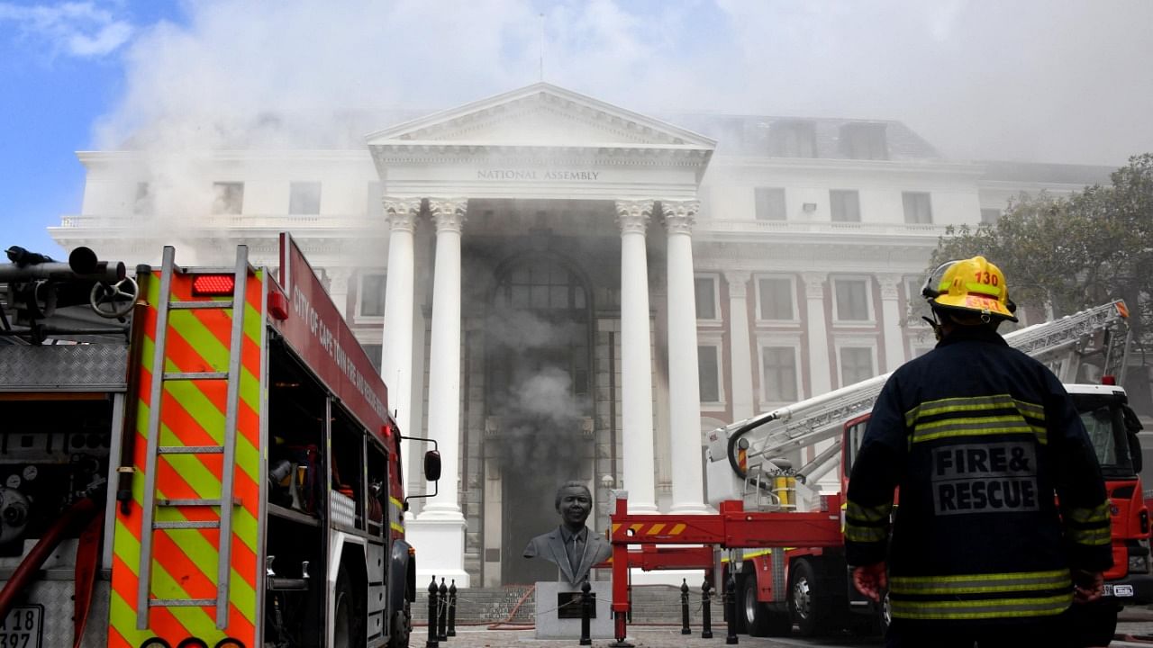 A firefighter looks at the smoke rising after a fire broke out in the Parliament in Cape Town, South Africa. Credit: Reuters File Photo