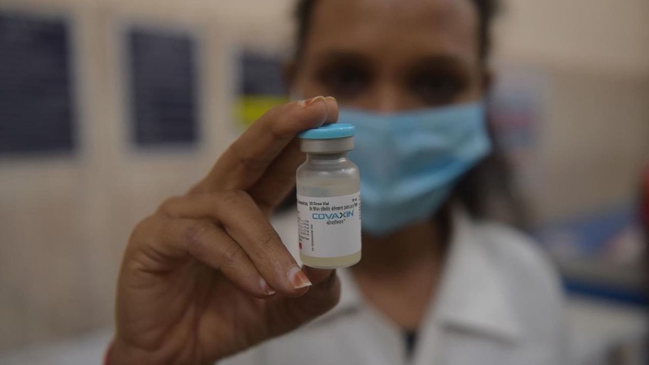 A health worker shows a vial containing the Covaxin vaccine against the Covid-19 Coronavirus to be given to youths between the age of 15 to 18, on the outskirts of Ahmedabad. Credit: AFP Photo