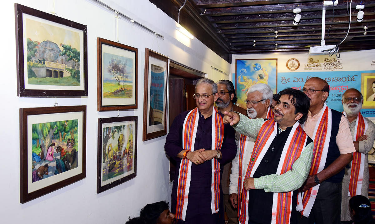 Karnataka Lalita Kala Academy Chairman Mahendra D and former MLC Capt Ganesh Karnik among others look at artworks during an exhibition of works by M T V Acharya, on the occasion of his birth centenary year, organised by Karnataka Lalita Kala Academy at Art Canara Trust in Mangaluru on Monday.