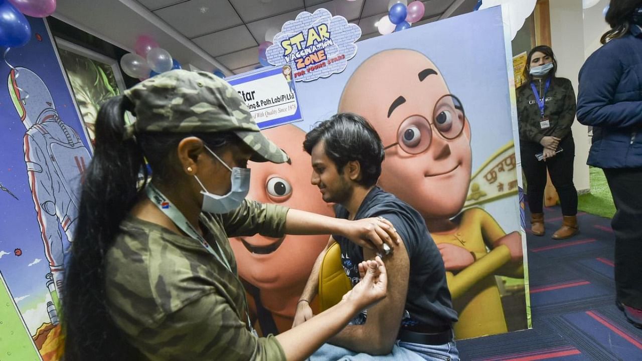  A health worker administers a dose of Covid-19 vaccine to a teenager, at a vaccination centre in New Delhi. Credit: PTI Photo