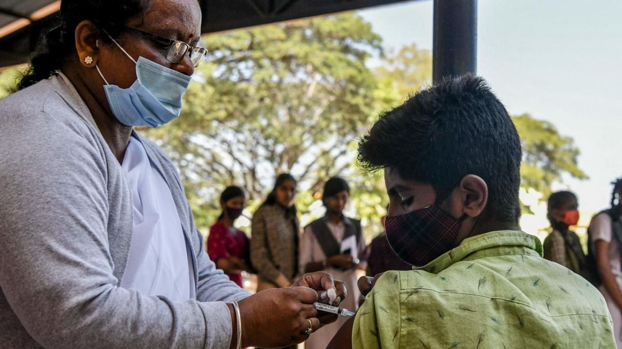 A health worker inoculates a student with a dose of the Covaxin vaccine against the Covid-19 coronavirus during a vaccination drive for people in the 15-18 age group, at the Nelamangala Government High School and Junior College in Bangalore on January 3, 2022. Credit: AFP Photo