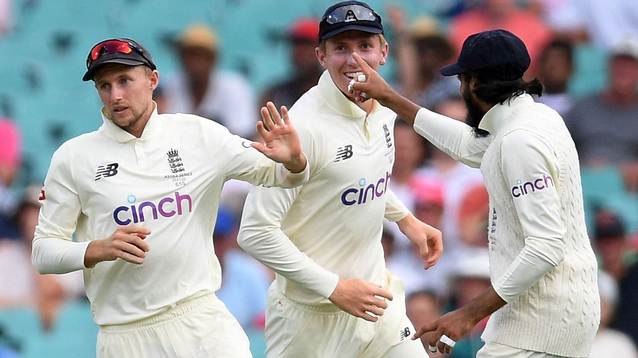 England's Joe Root celebrates with Zak Crawley and teammates after taking a catch to dismiss Australia's Marcus Harris off the bowling of James Anderson. Credit: Reuters Photo