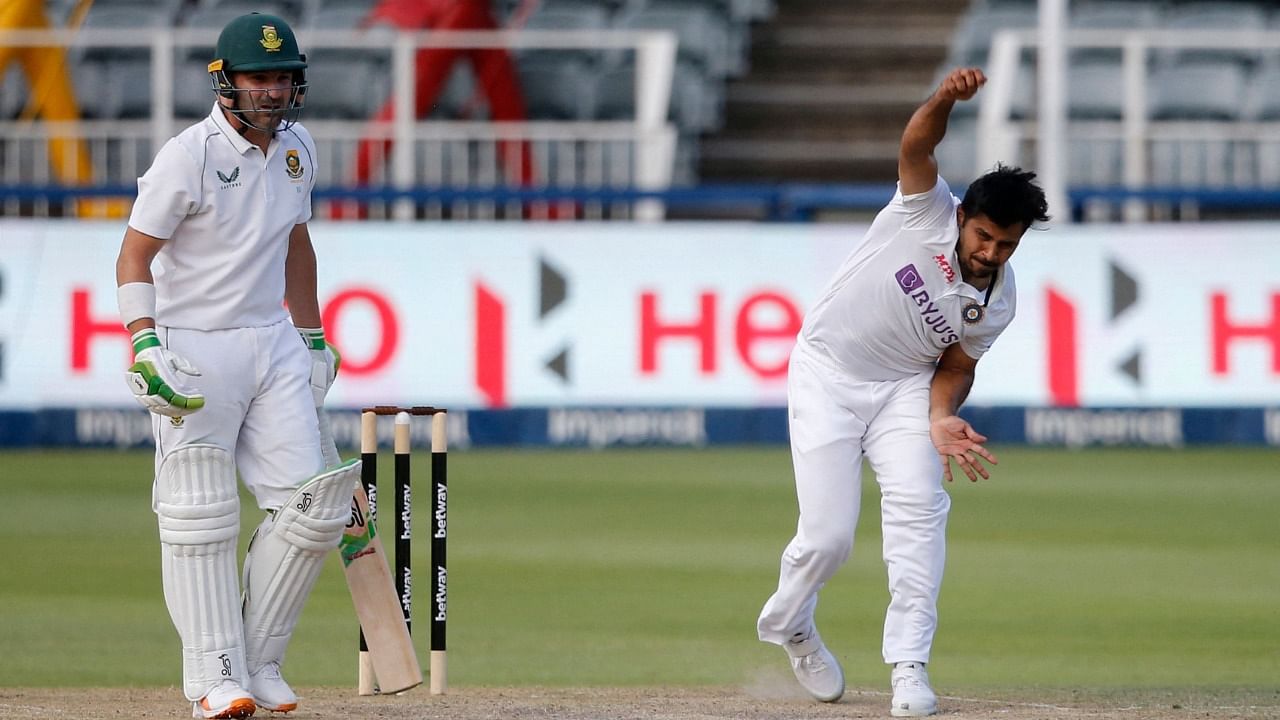 India's Shardul Thakur (R) delivers a ball as South Africa's Dean Elgar (L) looks on during the third day of the second Test cricket match between South Africa and India at The Wanderers Stadium in Johannesburg on January 5, 2022. Credit: AFP Photo