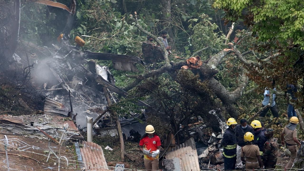 Rescuers stand near the debris of the Russian-made Mi-17V5 helicopter after it crashed near the town of Coonoor. Credit: Reuters file photo