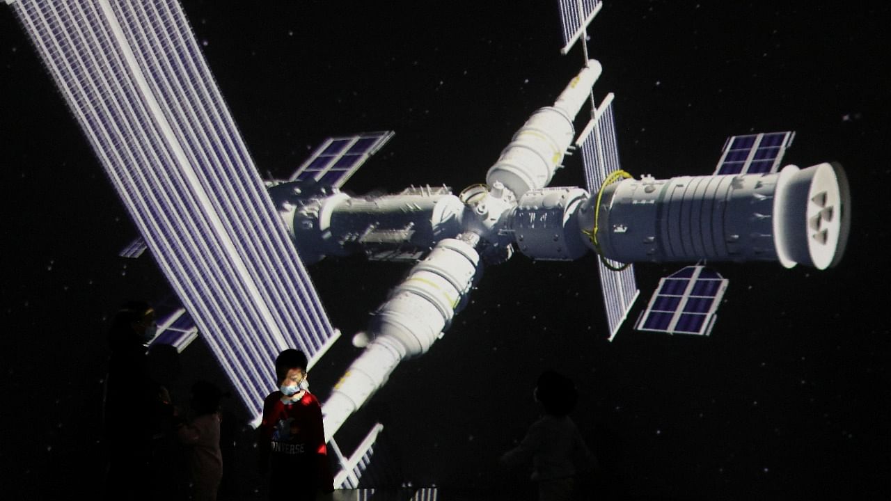 A child stands near a giant screen showing the image of the Tianhe space station on the country's Space Day at China Science and Technology Museum in Beijing. Credit: Reuters File Photo