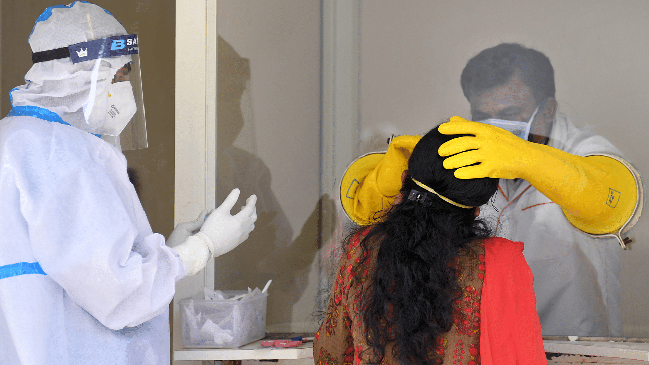 Healthcare workers collect swab sample from people for coronavirus. Credit: DH Photo