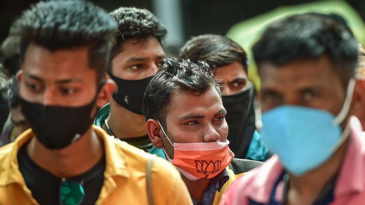 Passengers wearing face masks stand in a queue for Covid-19 test, amid fear of spread of the Omicron variant of COVID-19, at Krantiveer Sangoli Rayanna (KSR) railway station in Bengaluru. Credit: PTI Photo