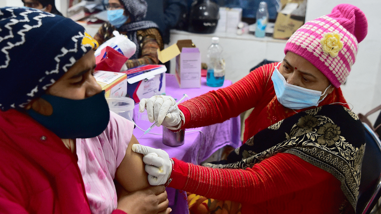 A health worker inoculates a youth with a dose of the Covaxin vaccine against the Covid-19. Credit: AFP Photo