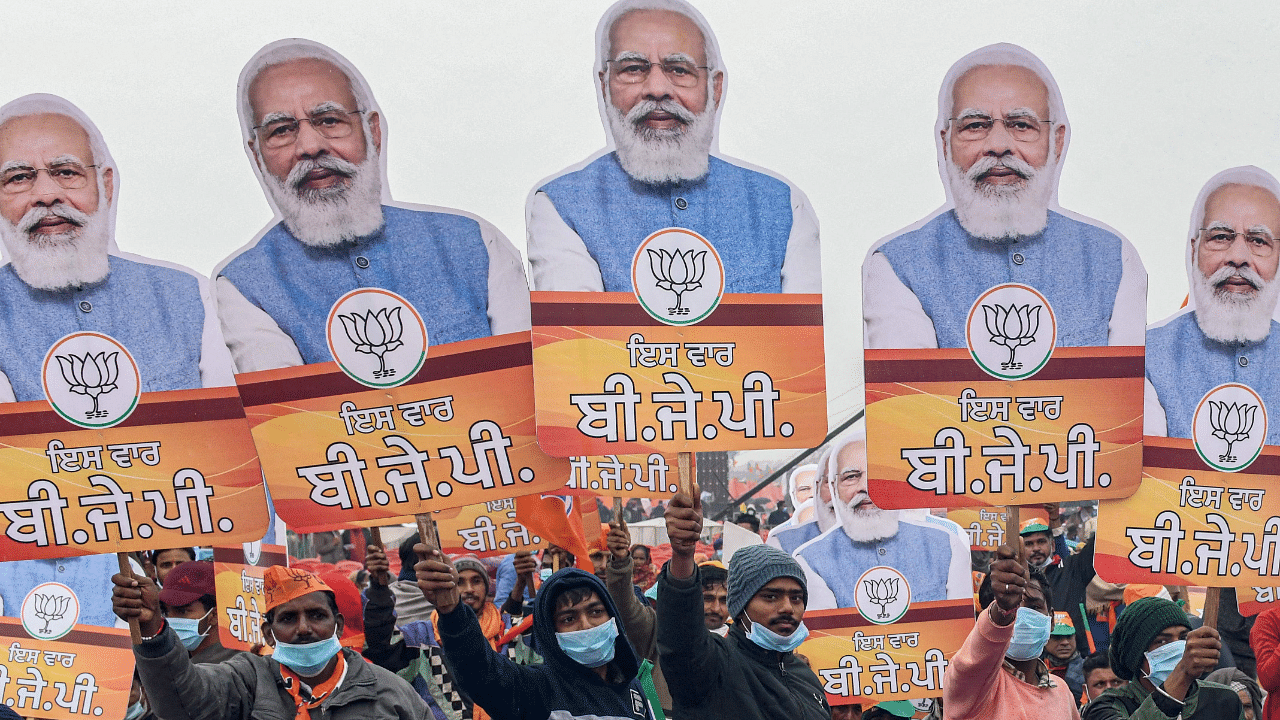 Bharatiya Janata Party (BJP) supporters hold BJP party flags and cut-outs with portrait of BJP leader and India's Prime Minister Narendra Modi. Credit: AFP Photo