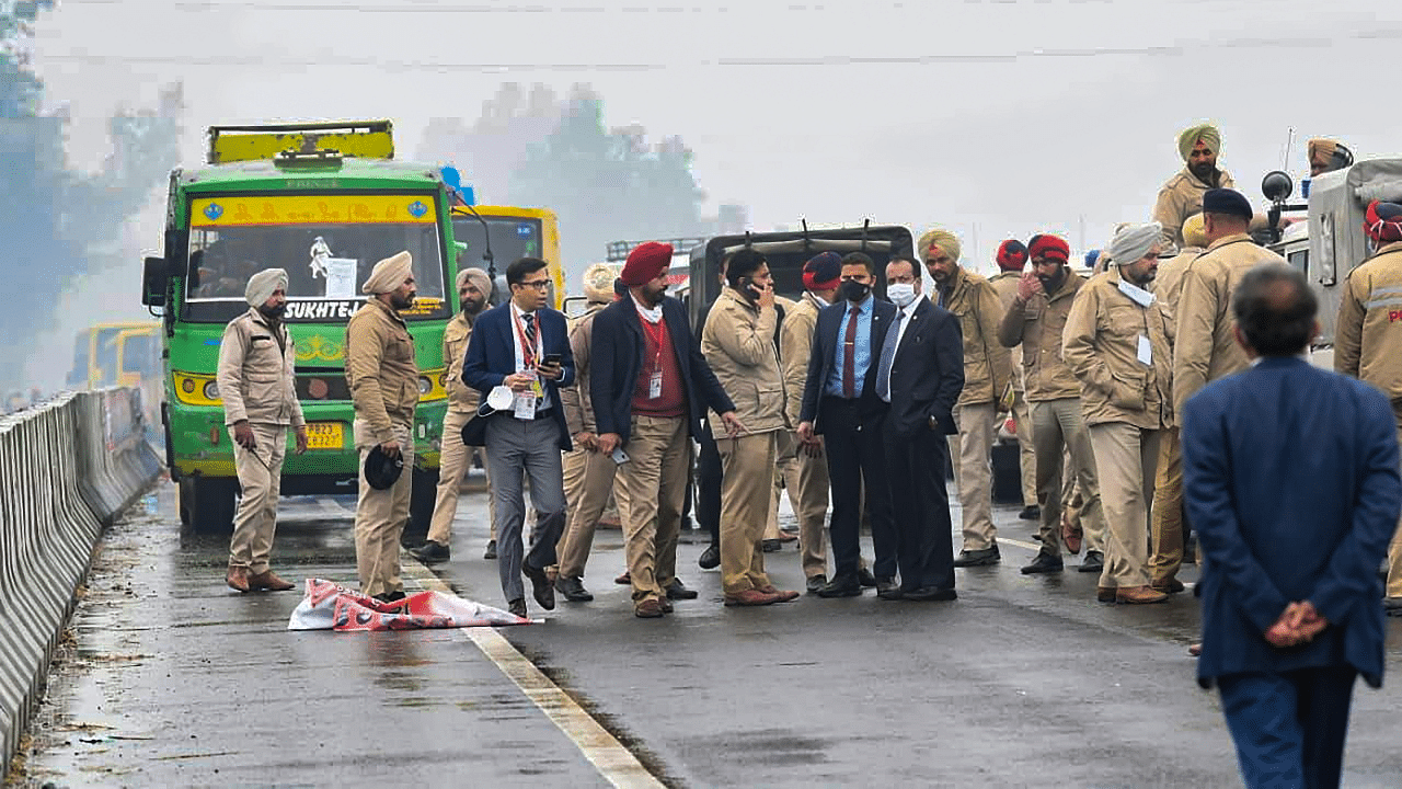 Police personnel and officials at the flyover where Prime Minister Narendra Modi's convoy stuck due to a blockade by a group of protestors. Credit: PTI Photo