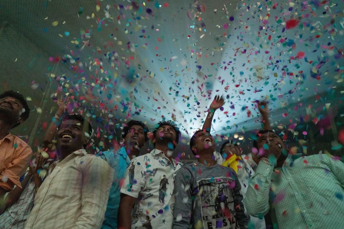 Audience celebrate the entry of actor Shivarajkumar during the screening of his 2019 film 'Ayushman Bhava' at the Santosh theatre in Bengaluru. 