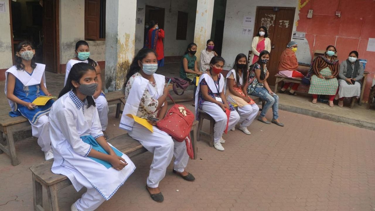 Students wait at the designated observation area after getting themselves inoculated with the Covaxin vaccine against the Covid-19 coronavirus during a vaccination drive organised for girls in the 15-18 age group, at Siliguri Hakimpara Girls school in Siliguri. Credit: AFP Photo