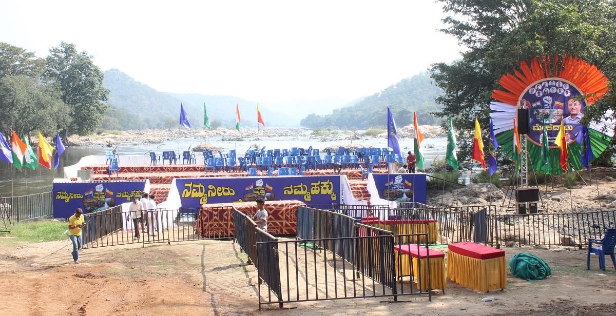 Preparations are on for setting up a stage for the launch of Mekedatu padayatra event on the banks of River Kaveri at Sangama in Kanakapura taluk of Ramanagara district on Sunday. Credit: DH Photo