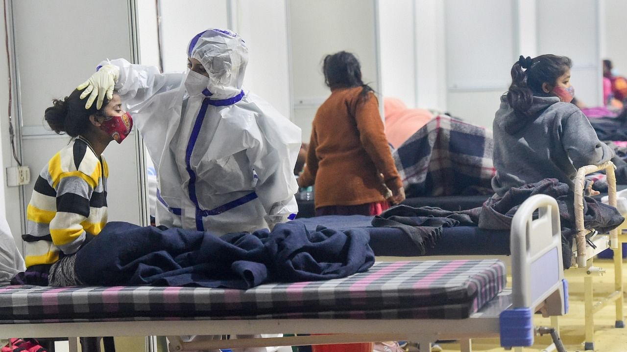 A health worker interacts with a Covid-19 infected patient inside the Covid Care Centre of the Commonwealth Games (CWG) village, in New Delhi. Credit: PTI Photo