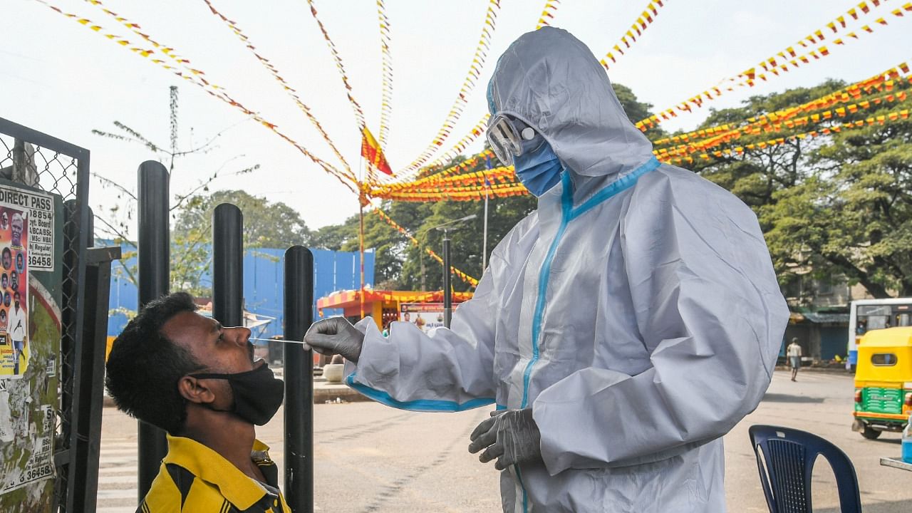 A BBMP health worker collects swabs for Covid testing at KR Market Circle on Sunday. Dh photo/S K Dinesh