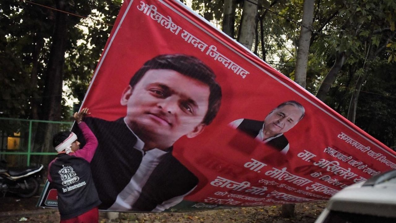 A UP administration worker removes a political banner as the Model Code of Conduct has come into effect after the announcement of the schedule of UP Assembly elections. Credit: PTI Photo