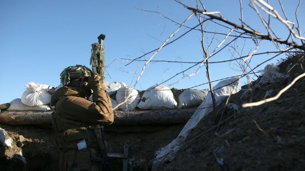Ukrainian Territorial Defense Forces, the military reserve of the Ukrainian Armes Forces watches through spyglass on a trench on the frontline with Russia-backed separatists near to Avdiivka, southeastern Ukraine. Credit: AFP Photo