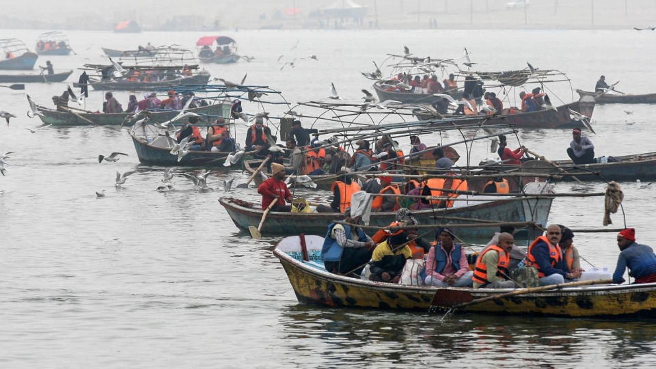 Devotees arrive on boats to take a holy dip at Sangam, amid Covid pandemic, in Prayagraj, Tuesday, Jan. 11, 2022. Credit: PTI Photo