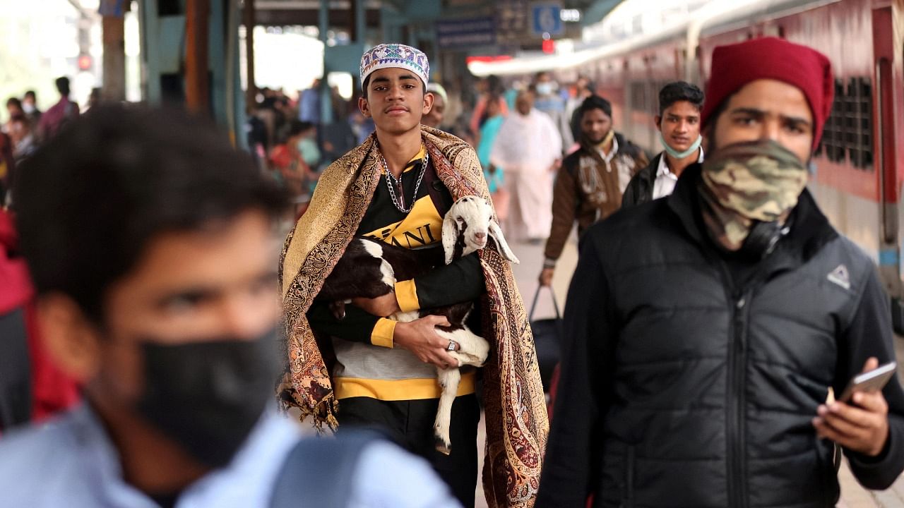 A man carries a goat after deboarding a train at a railway station, amidst the spread of coronavirus disease, in Mumbai, India, January 13, 2022. Credit: Reuters Photo