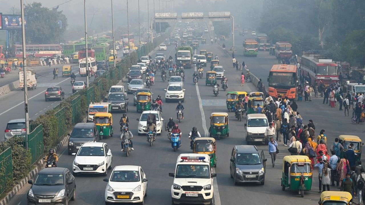 eople commute along a street in vehicles amid smoggy conditions in New Delhi. Credit: AFP Photo