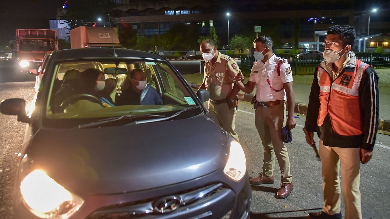 Police stop a vehicle during the weekend curfew, imposed to curb the spread of Covid-19, in Bengaluru. Credit: PTI Photo