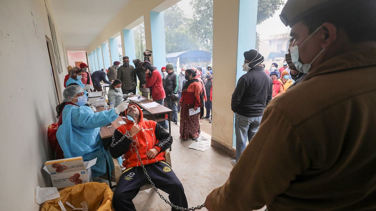 A health worker collects sample of residents for Covid-19 test, in Jammu. Credit: PTI File Photo