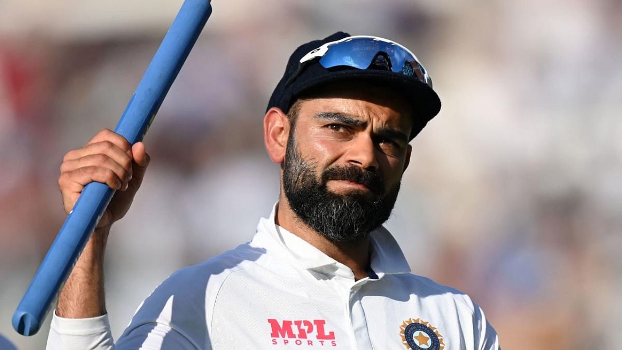 India's captain Virat Kohli holds aloft a stump as he leaves the field after India won the fourth cricket Test match between England and India at the Oval cricket ground in London. Credit: AFP Photo