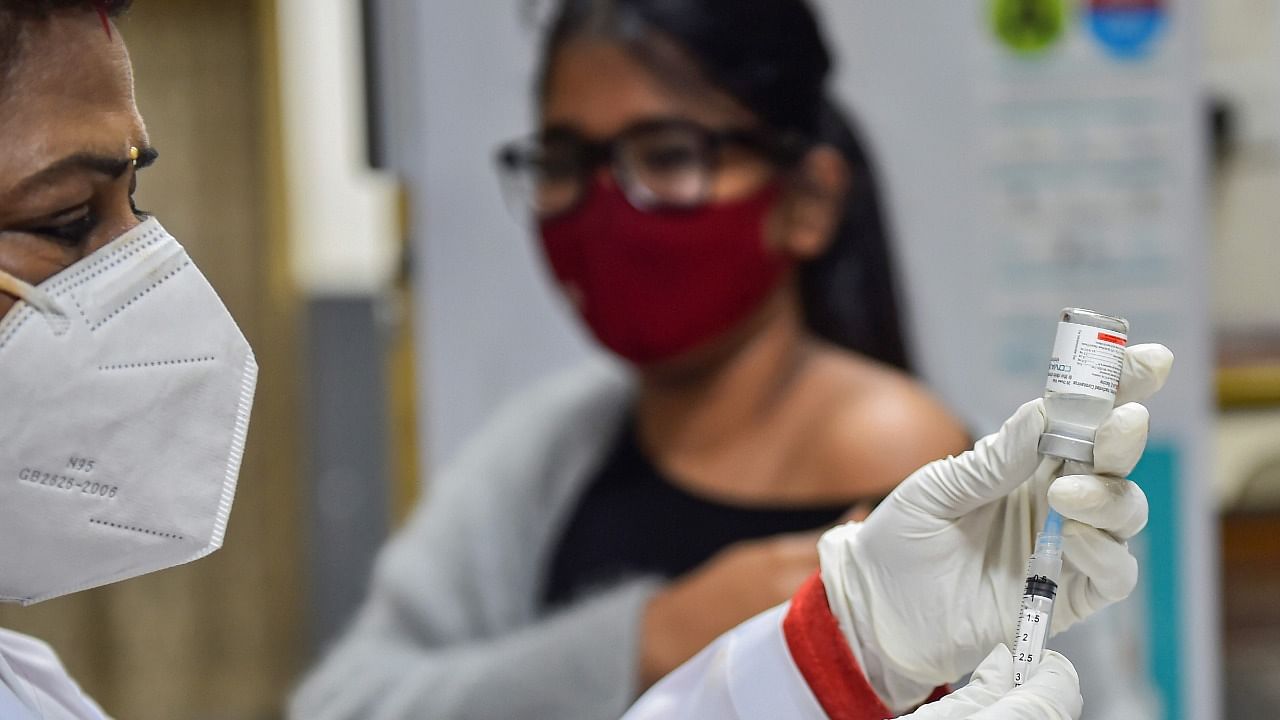 A health worker prepares a dose of Covid-19 vaccine before administering it to a teenager, in New Delhi, Saturday. Credit: PTI Photo