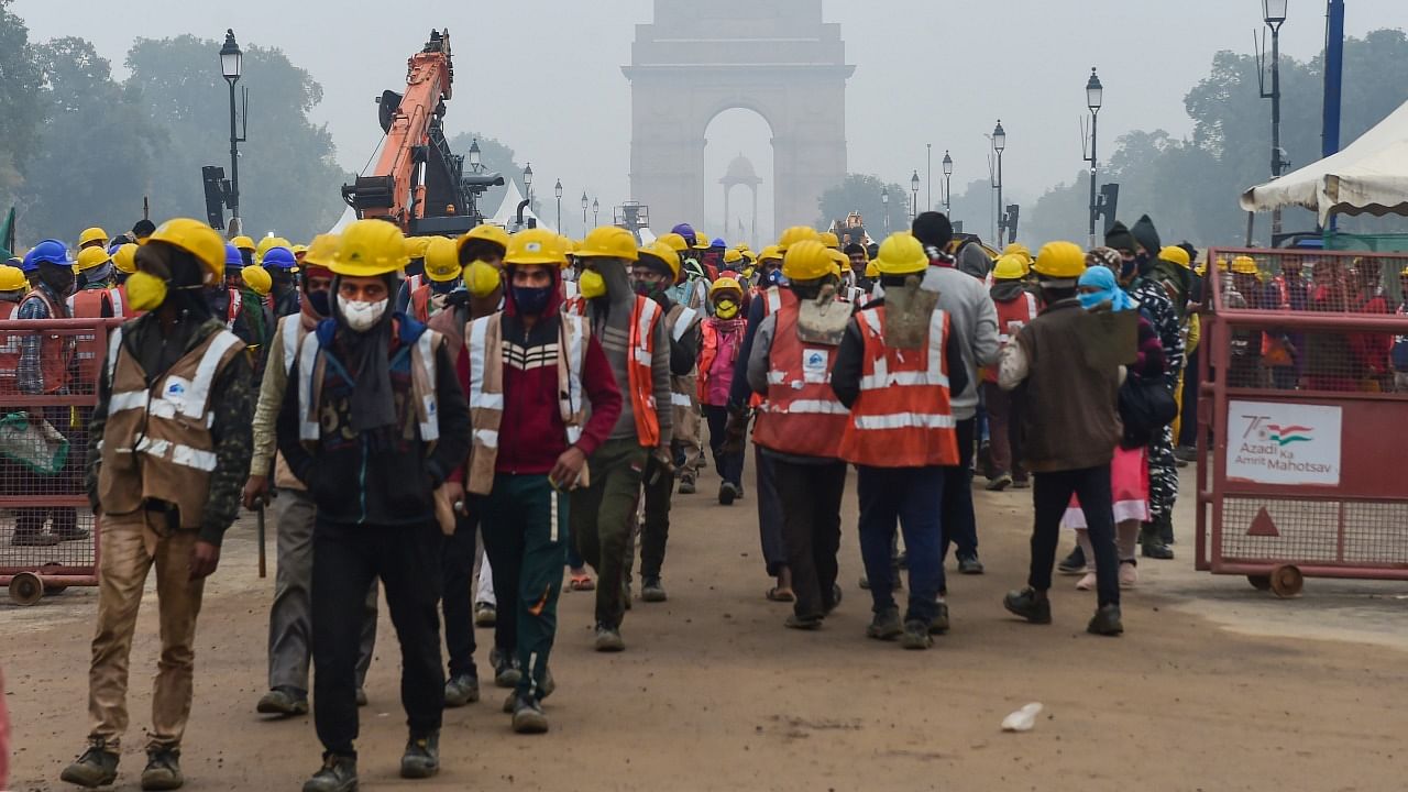 Labourers arrive at Rajpath to work on the Central Vista project, on a cold winter morning in New Delhi. Credit: PTI File Photo
