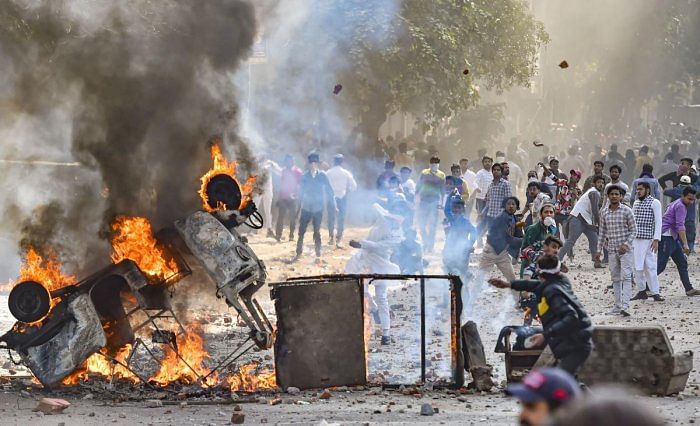 Vehicles set ablaze as protestors throw brick-bats during clashes between a group of anti-CAA protestors and supporters of the new citizenship act, at Jafrabad in north-east Delhi, Monday, Feb. 24, 2020. Credit: PTI Photo