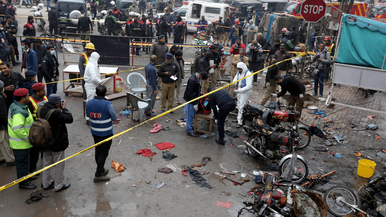 Police officials and investigators examine the site of bomb explosion, in Lahore, Pakistan. Credit: AP Photo
