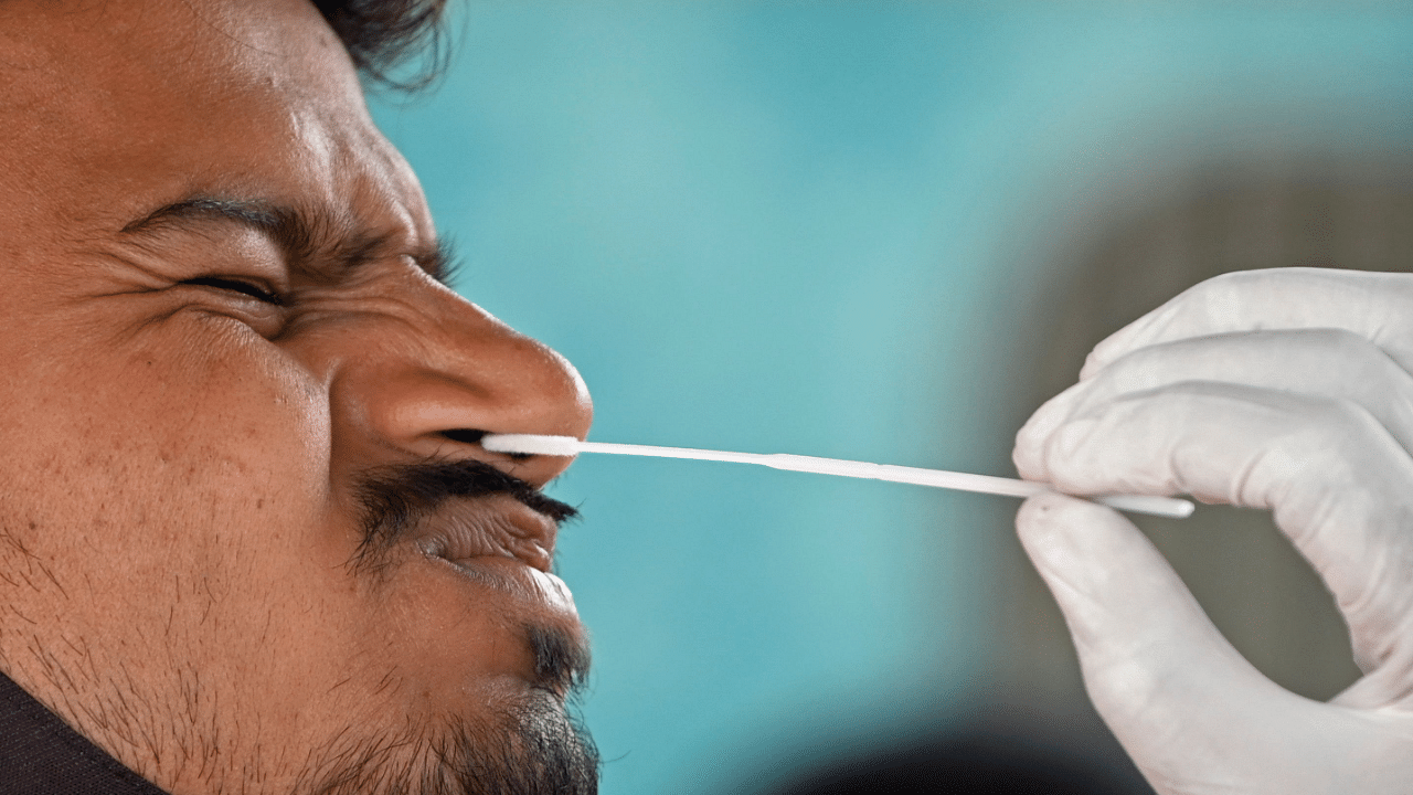 A health worker collects a swab sample for RAT (Rapid Antigen Test) of an arriving passenger at a railway station during a mandatory Covid-19 coronavirus screening in Mumbai. Credit: AFP Photo