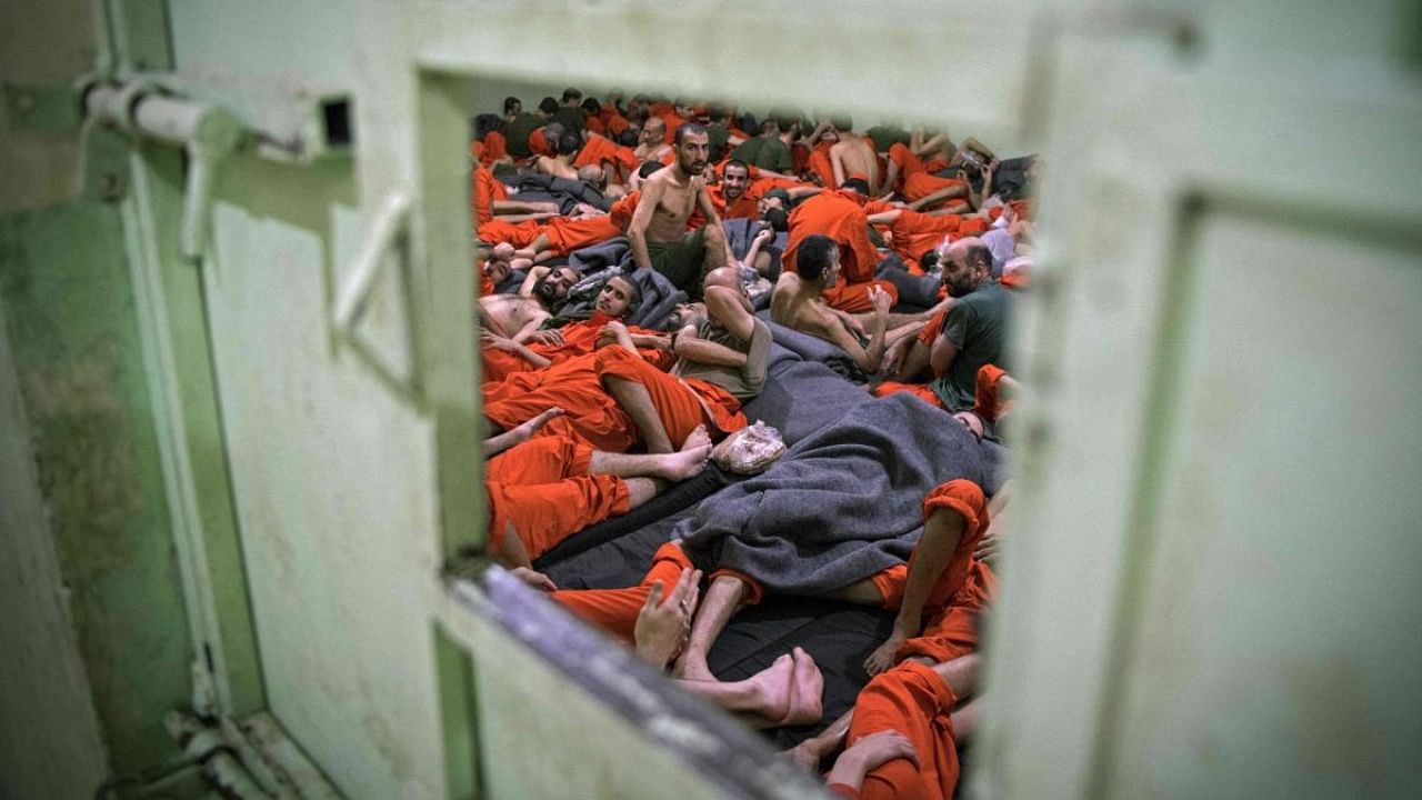 This file photo taken on October 26, 2019, shows men suspected of being affiliated with the Islamic State (IS) group, gathered in a prison cell in the northeastern Syrian city of Hasakeh. Credit: AFP Photo