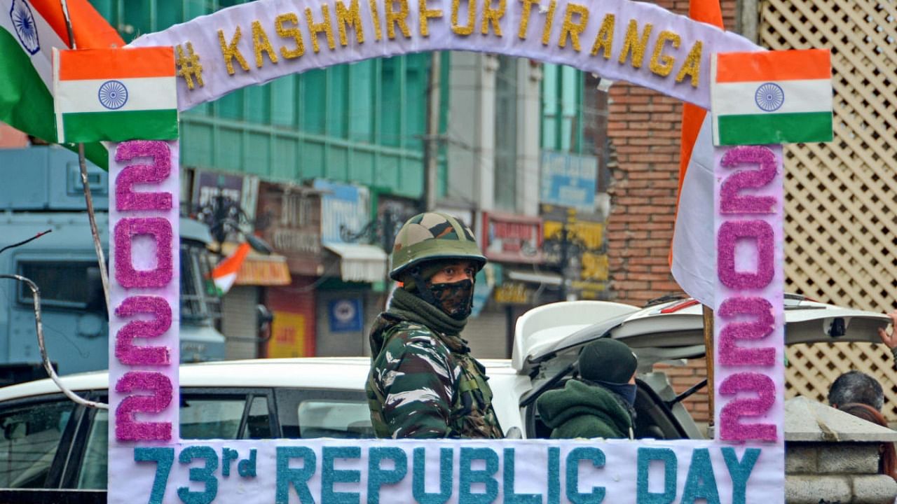 A security jawan stands guard at historical Ghanta Ghar in Lal Chowk area decorated with tricolour flags during the 73rd Republic Day celebrations, in Srinagar. Credit: PTI file photo