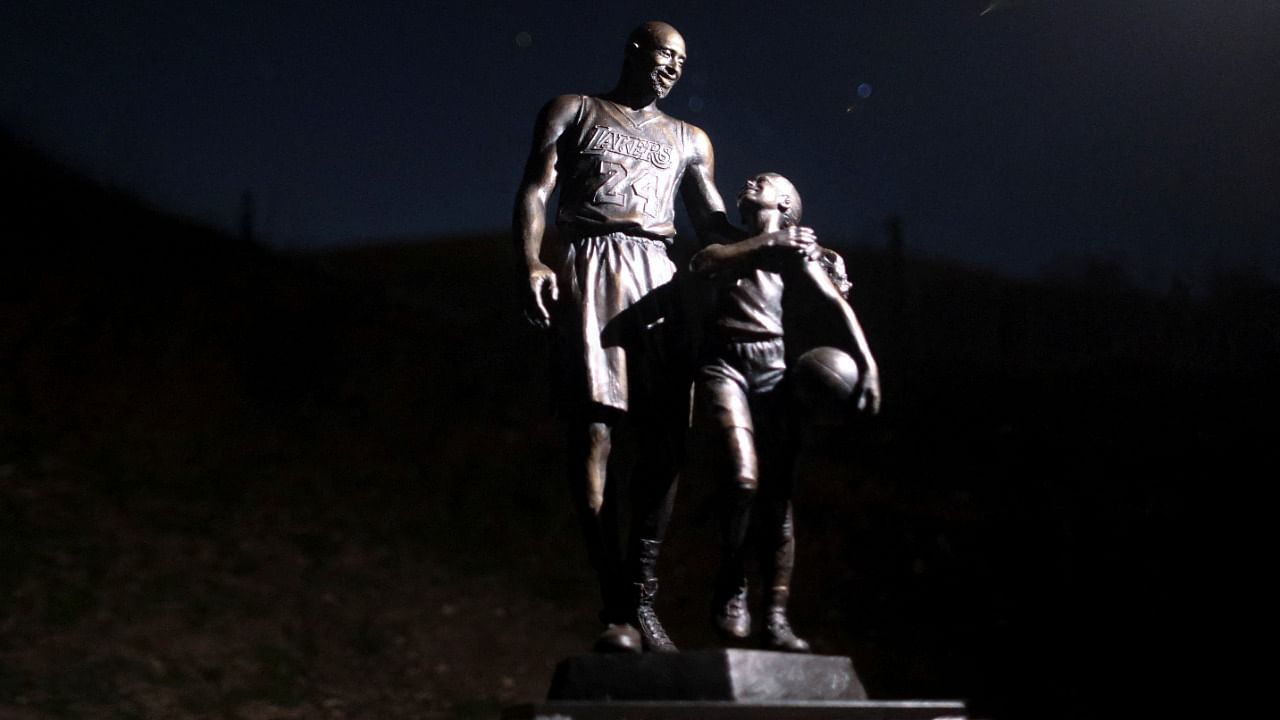 The statue features Kobe Bryant in full uniform with his arm around Gianna, who is holding a basketball. The names of all crash victims adorn the base. Credit: Reuters Photo