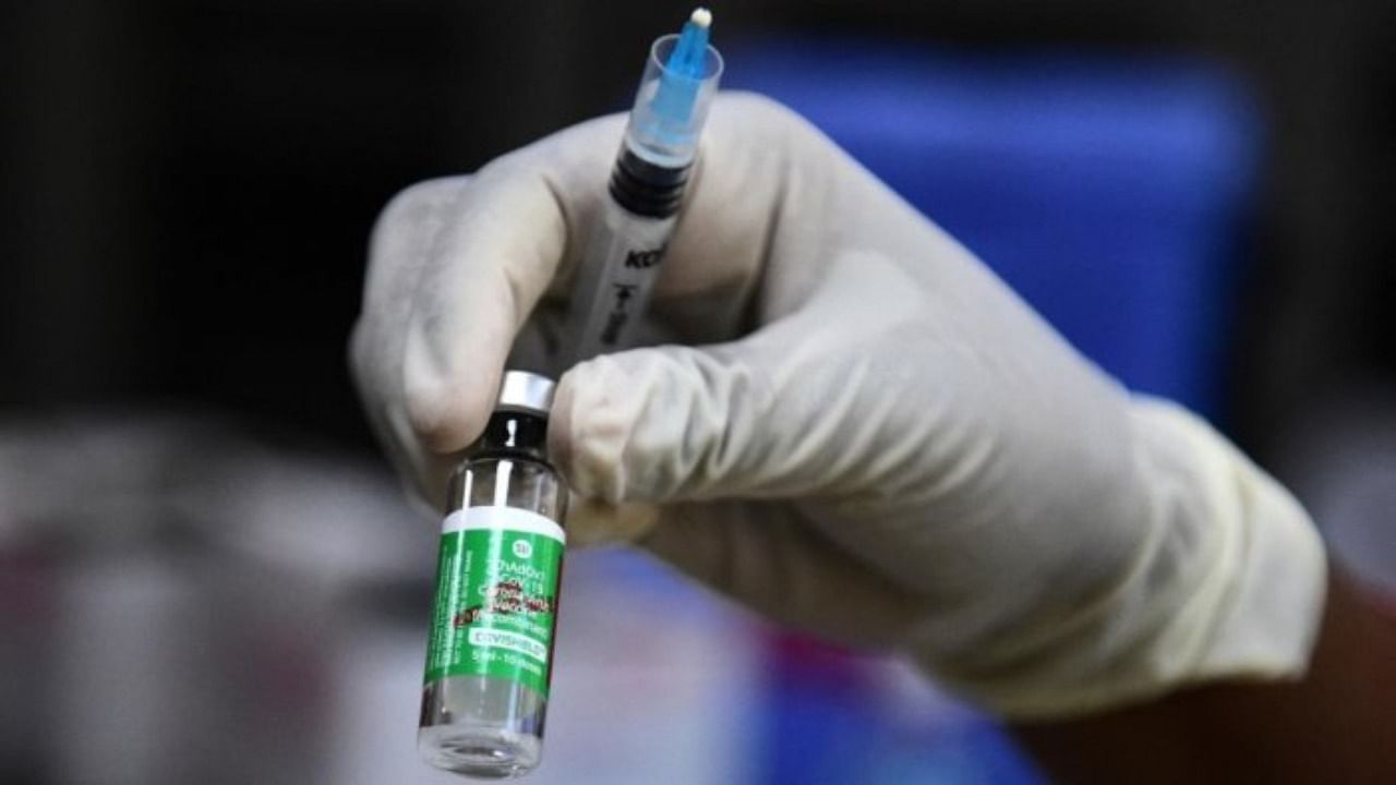 A medical worker holds a vial of the Covishield vaccine. Credit: AFP Photo