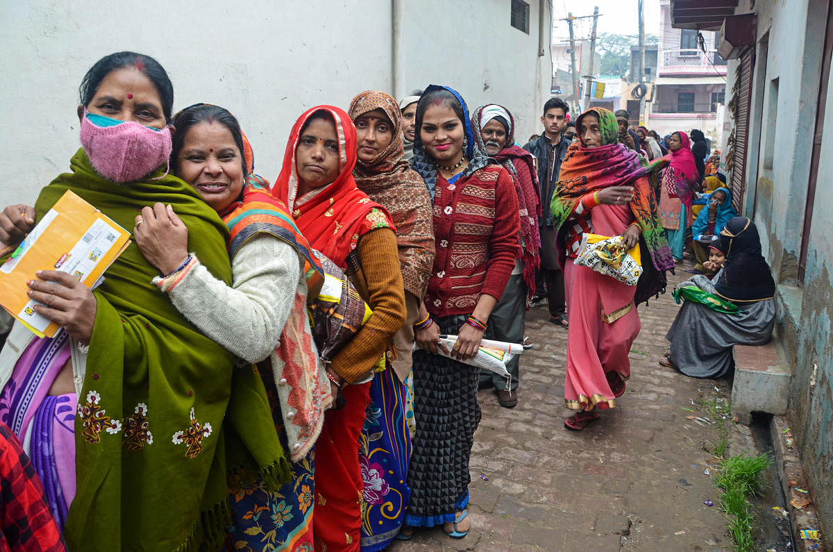 Mathura: Women, not wearing masks, stand in a queue to receive free ration during the third wave of COVID-19, outside a government shop in Mathura, Monday, Jan. 10, 2022. (PTI Photo)(PTI01_10_2022_000086B)