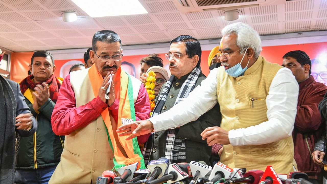 Union Minister and BJP's election in-charge for Uttarakhand Pralhad Joshi (C) and Uttarakhand BJP President Madan Kaushik (R) with former Congress leader Kishore Upadhyay. Credit: PTI Photo