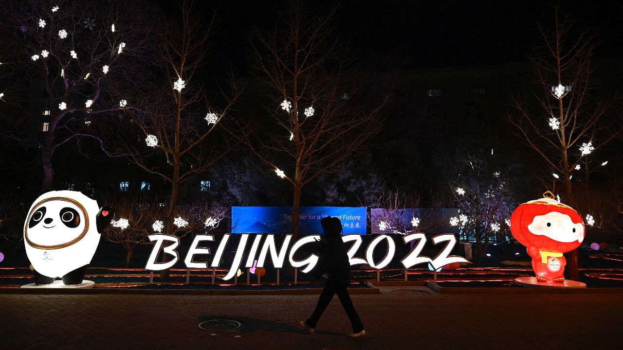A woman walks past installations of Bing Dwen Dwen (L) and Shuey Rhon Rhon (R), mascots of the Beijing 2022 Winter Olympics Games. Credit: AFP Photo