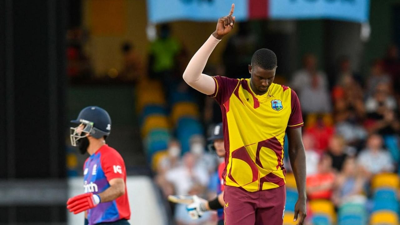 Jason Holder (R) of West Indies celebrates the dismissal of Moeen Ali (L) of England during the 4th T20I between West Indies and England at Kensington Oval, Bridgetown. Credit: AFP Photo