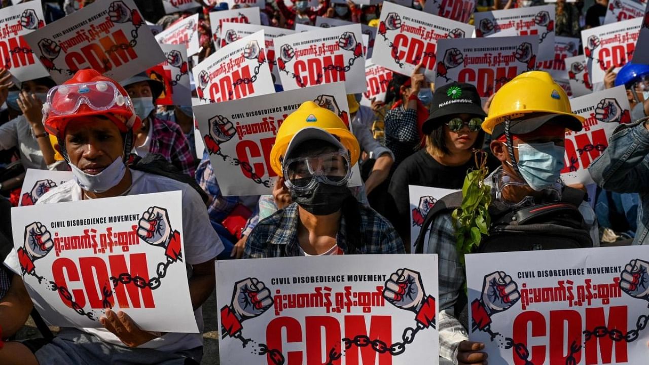 In this file photo taken on February 14, 2021 protesters hold up signs supporting the Civil Disobedience Movement (CDM) at a demonstration against the military coup in Yangon. Credit: AFP file photo