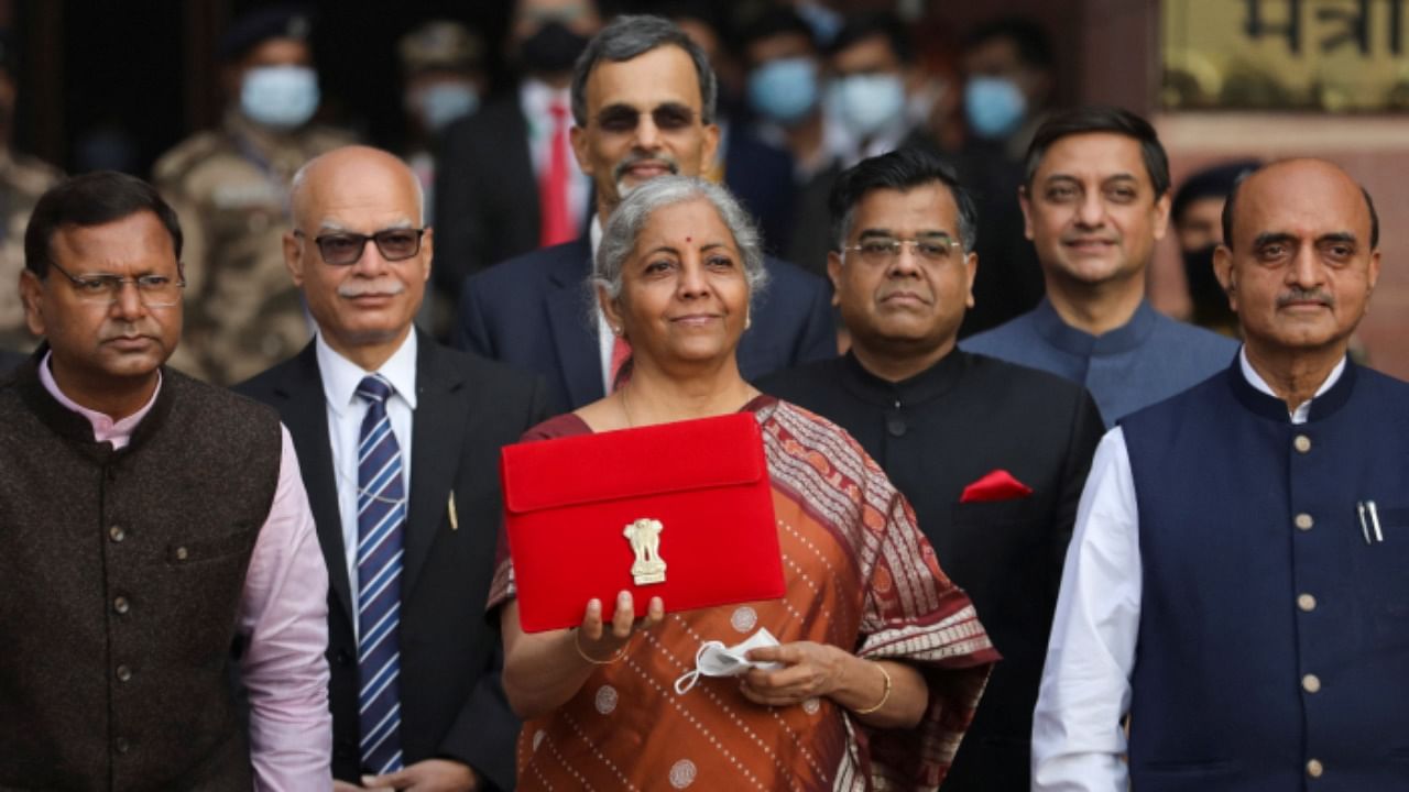 Union Finance Minister Nirmala Sitharaman holds a folder-case containing the Union Budget 2022-23 as she poses for a photograph with the Finance Ministry officials, outside the North Block. Credit: PTI Photo  