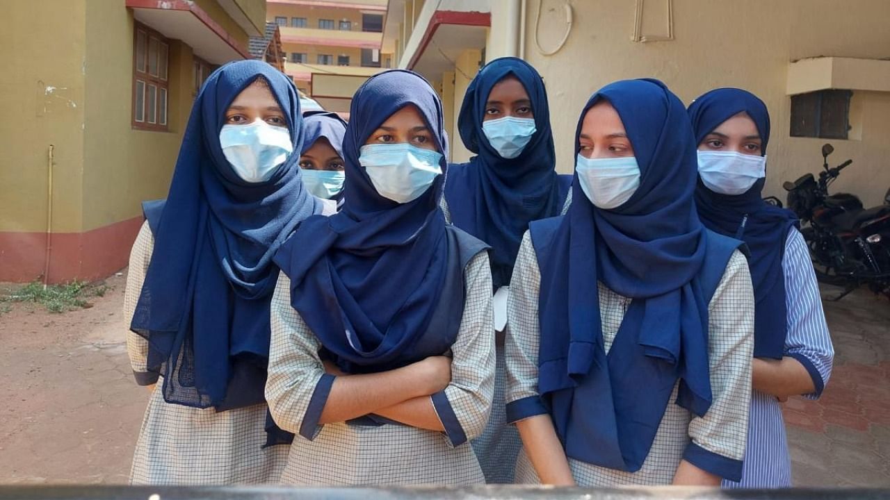 Six students of the government Pre-University College in Udupi stand outside as the college administration denied permission to classrooms for wearing hijab on Tuesday. The college development committee recently took a decision not to permit those in hijab inside the classrooms. Credit: DH photo